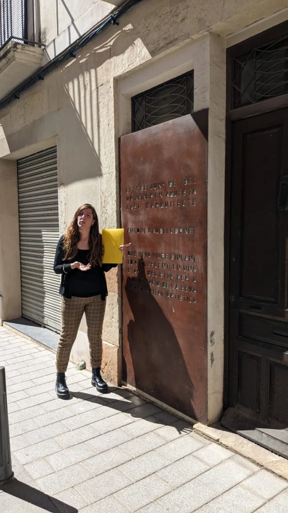 Tour guide in front of Antoni Gaudí's birthplace in Reus, explaining its historical significance to visitors.